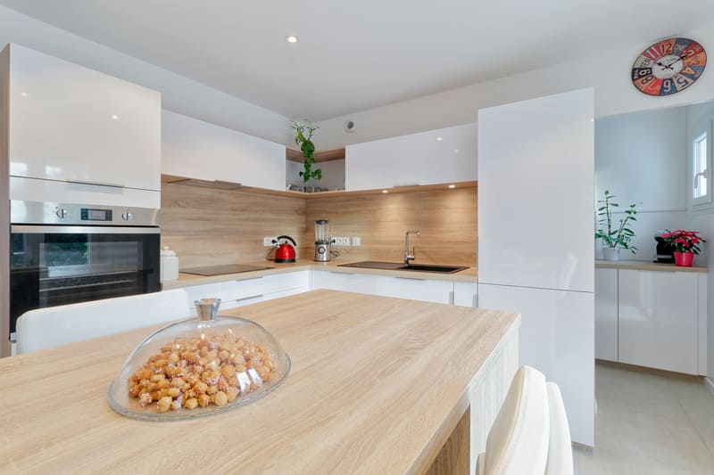 Cuisine blanche et bois avec îlot coin repas à Nemours | Raison Home